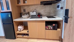 Una cucina compatta con mobili in legno, un forno a microonde integrato e un lavello.
