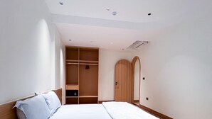 Una camera da letto moderna con un letto a scomparsa, un'armadiatura in legno e una piccola cabina armadio.