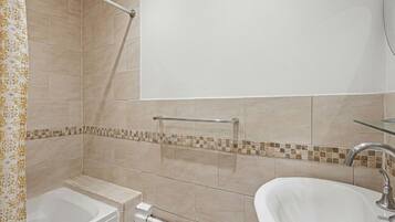 Une salle de bain avec une baignoire, un lavabo et une douche.