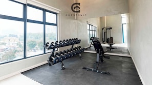 A gym with dumbbells, a bench press, and a treadmill. - Astrum Ampang by Guestonic (Kuala Lumpur)