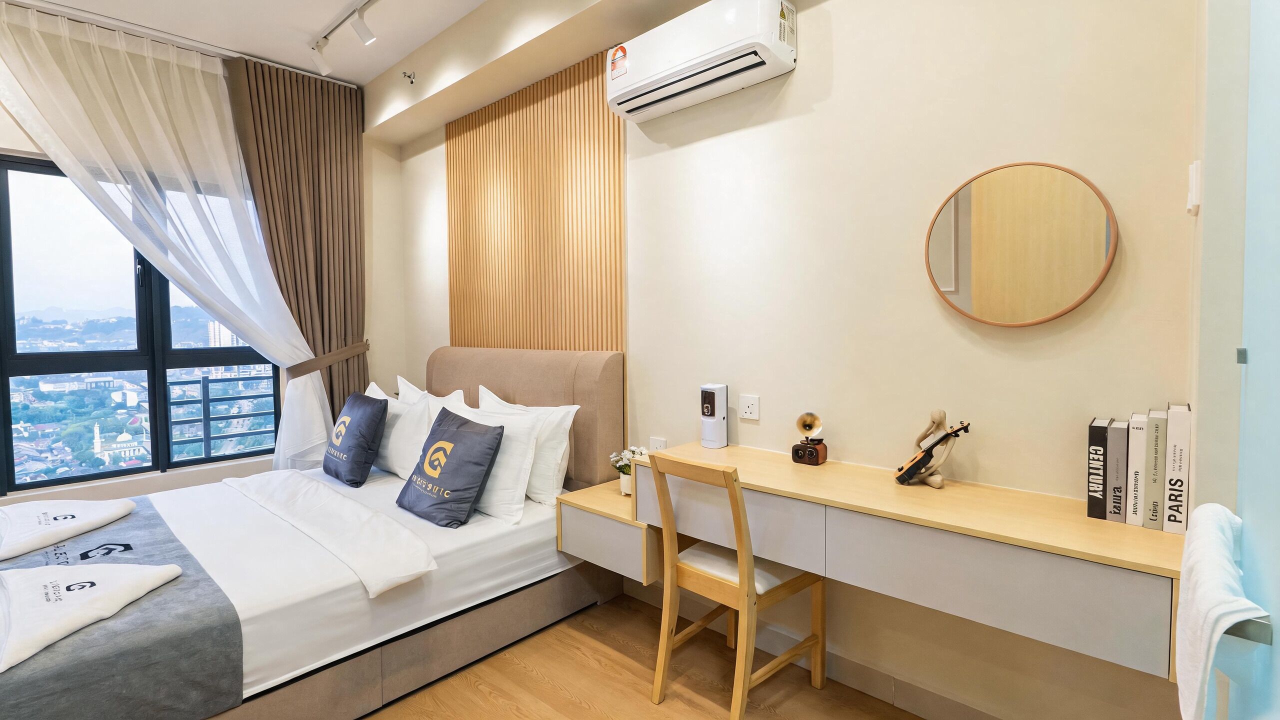 Habitación de hotel con cama, escritorio, silla, espejo y ventana con vistas.