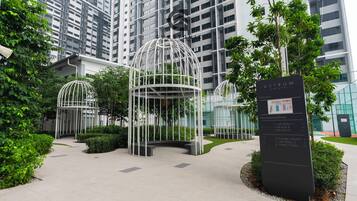 A modern building with a glass facade, surrounded by greenery and featuring two white, dome-shaped structures.