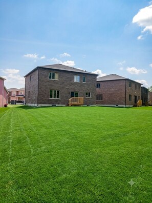 A multi-story building with a flat roof and brick exterior, surrounded by a well-maintained lawn.