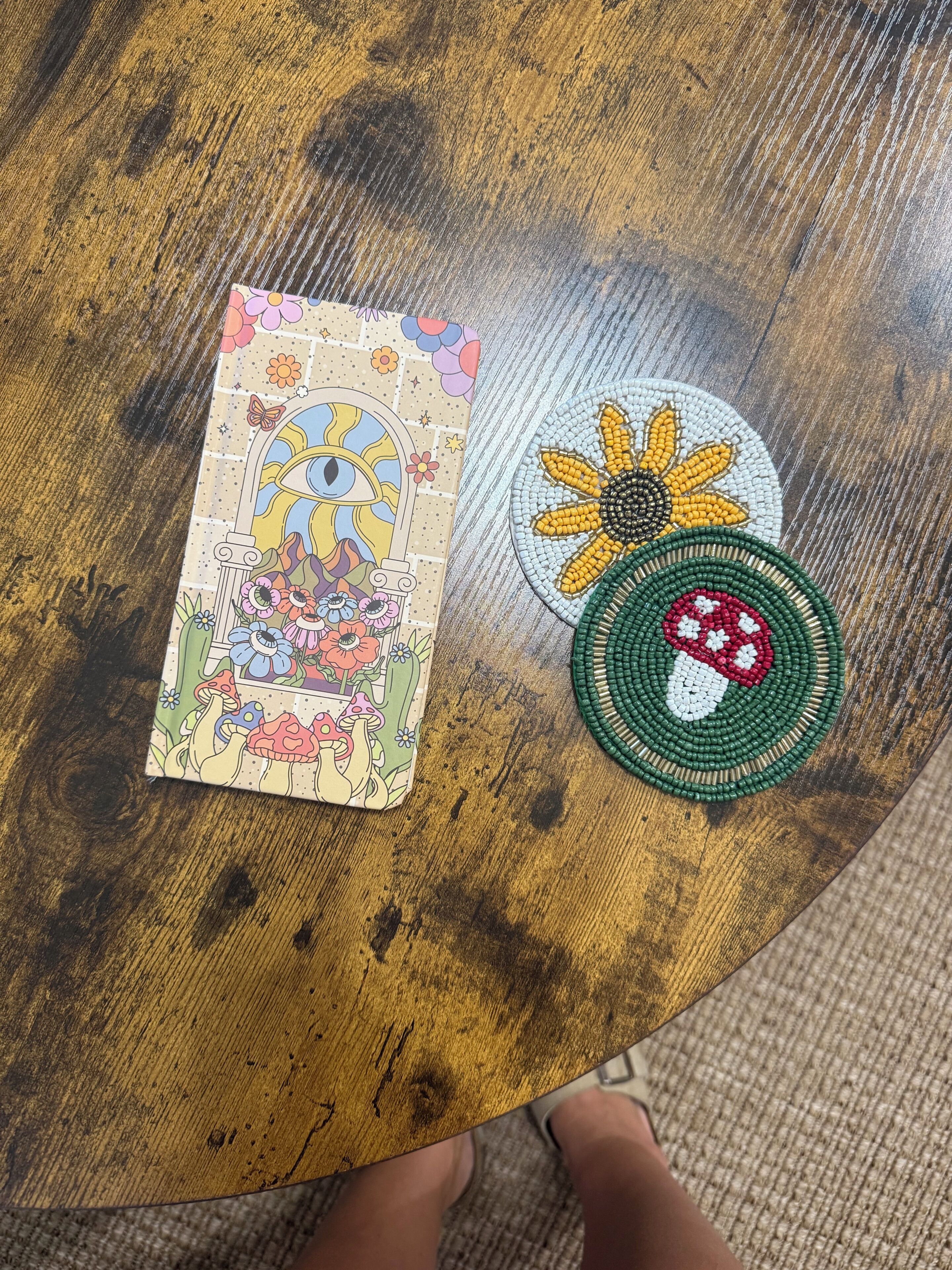 Una mesa de madera con una tarjeta de colores y dos posavasos con cuentas.