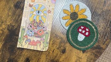 Una mesa de madera con una tarjeta de colores y dos posavasos con cuentas.