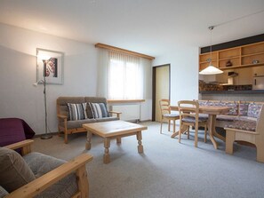 A cozy living room with a sofa, a coffee table, and a dining area with chairs and a table. - Gadastatt, Obersaxen-Valata, (Surcuolm), 38041B by Interhome (Obersaxen Surcuolm)