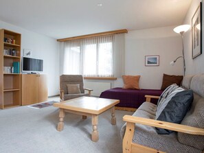 Ein möbliertes Wohnzimmer mit Sofa, Sessel und Couchtisch.