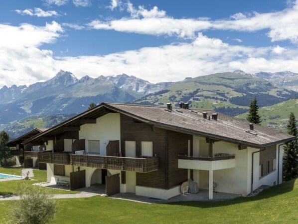 A chalet with a balcony, a pool, and a mountainous backdrop. - Gadastatt, Obersaxen-Valata, (Surcuolm), 38041B by Interhome (Obersaxen Surcuolm)