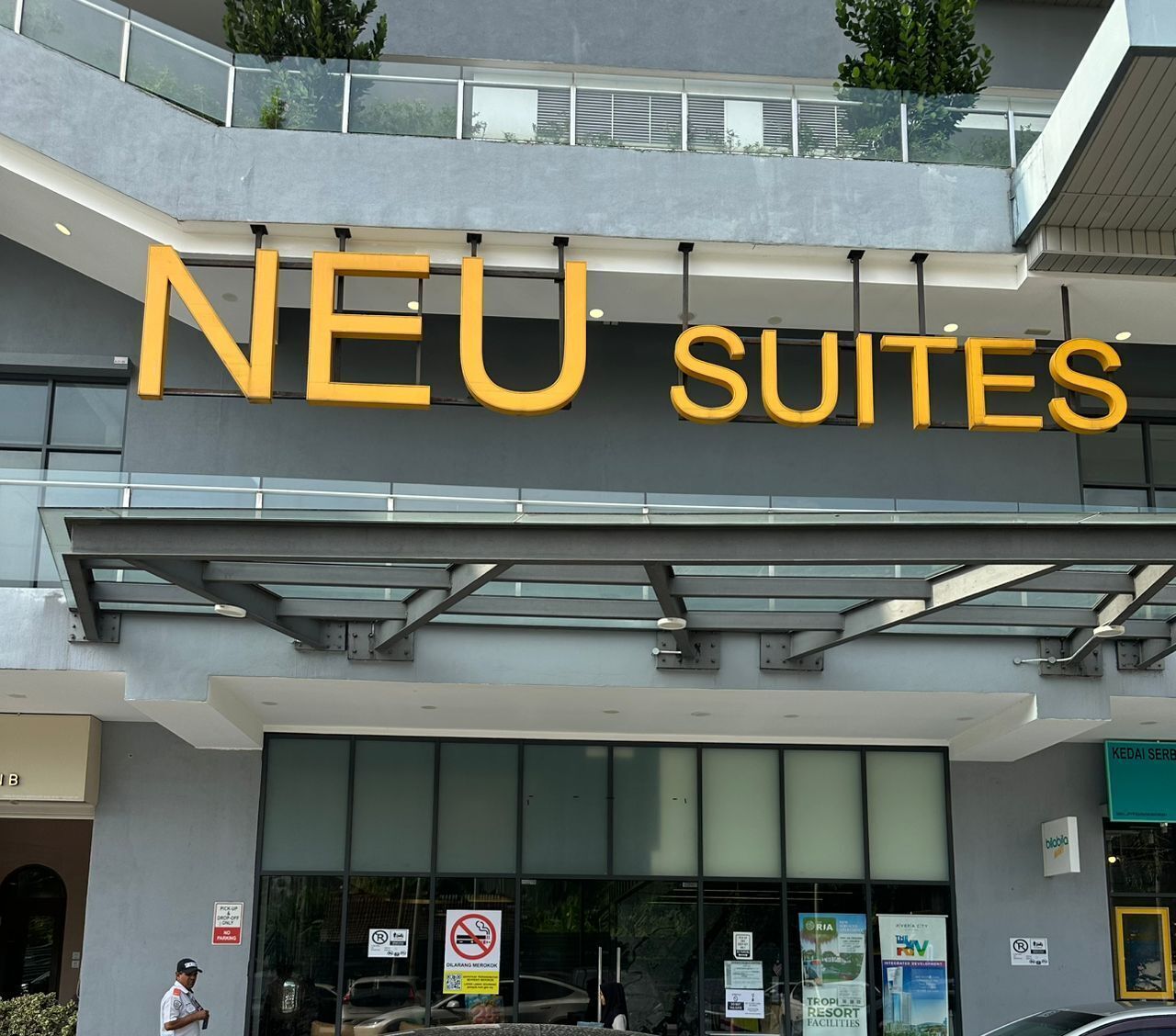 A hotel sign with 'NEU SUITES' written in large letters.