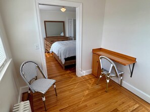 A bedroom with a wooden bed, a desk, two patterned chairs, and a mirror. - Year round 1-bedroom coastal LOFT, sleeps 6, in charming Portsmouth RI (Portsmouth)