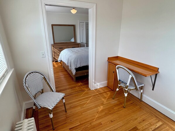 A bedroom with a wooden bed, a desk, two patterned chairs, and a mirror. - Year round 1-bedroom coastal LOFT, sleeps 6, in charming Portsmouth RI (Portsmouth)