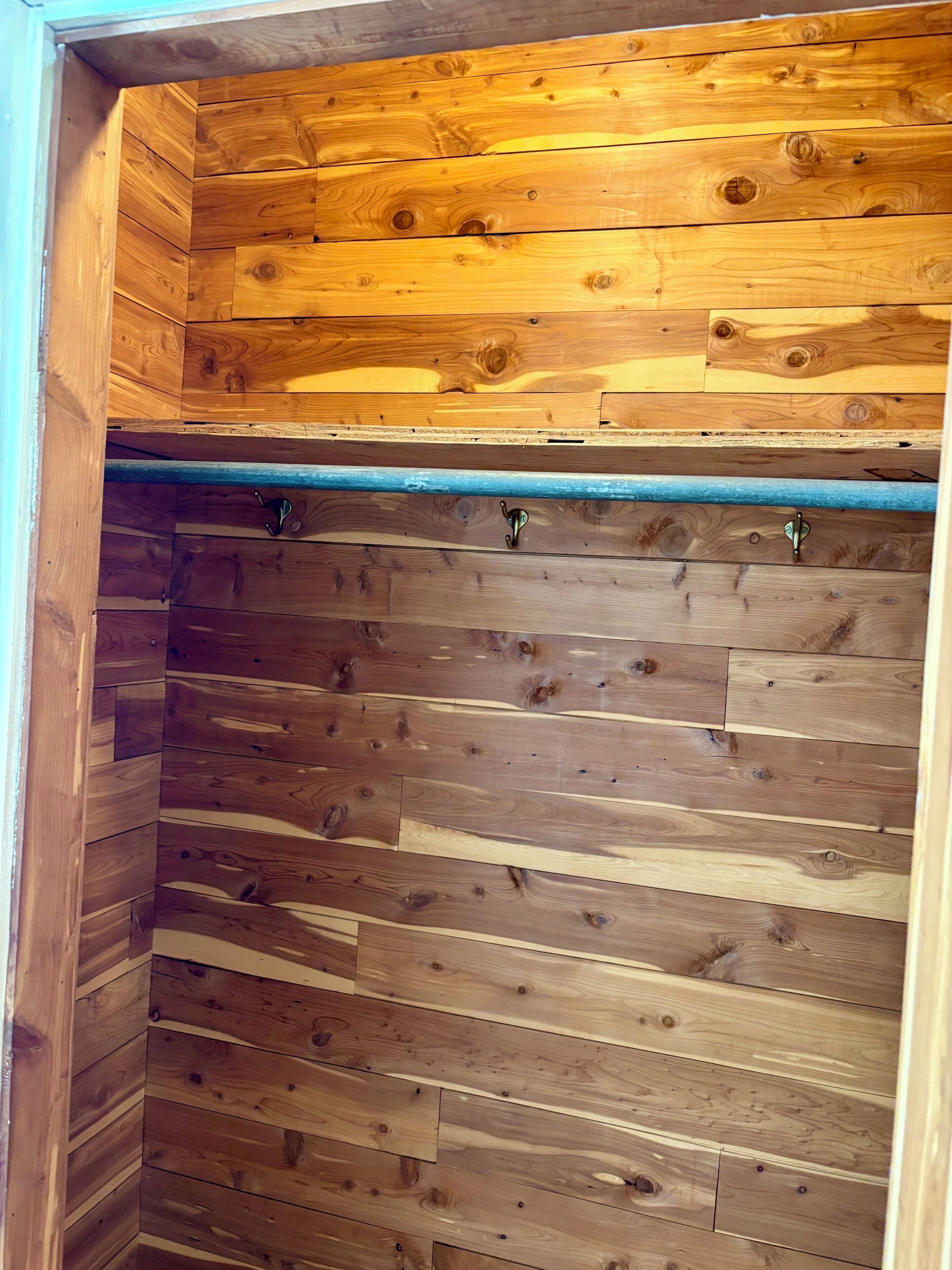 Un interior de madera con techo inclinado y una tubería azul horizontal.