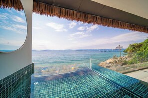 Una piscina de borde infinito con vistas al mar y montañas lejanas.