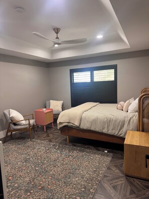 A bedroom with a bed, a chair, a small table, a ceiling fan, and a window with blinds. - Spacious and beautifully appointed designer 7-bedroom house in Paradise Valley (Paradise Valley)