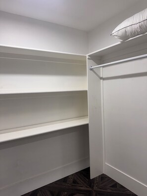 A closet with white shelving and a hanging rod, wooden flooring, and a white door. - Spacious and beautifully appointed designer 7-bedroom house in Paradise Valley (Paradise Valley)
