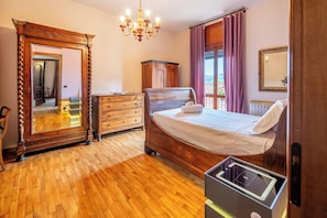 A bedroom with a wooden bed, a dresser, a mirror, and a chandelier. - Dimora Berzia - Two Bedroom Apartment, Sleeps 2 (Alba)