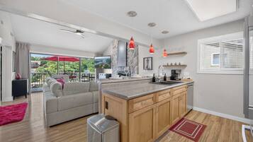 Une cuisine moderne avec des meubles en bois, un îlot central et des luminaires suspendus.