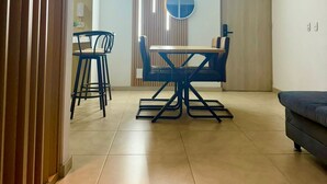 Un espace repas moderne avec une table ronde et des chaises, une cloison en bois et un canapé.