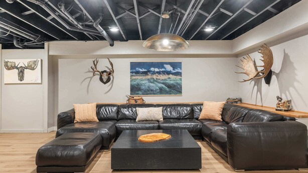 Una sala de estar moderna con un sofá modular, una mesa de centro y cornamentas de ciervo montadas en la pared.