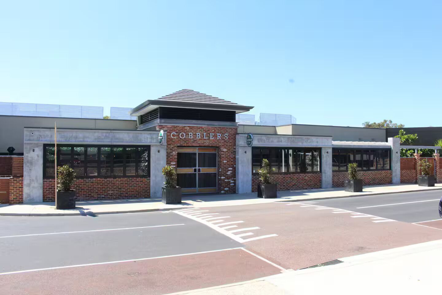 A building with a sign reading 'COBBLES' and a parking lot in front.