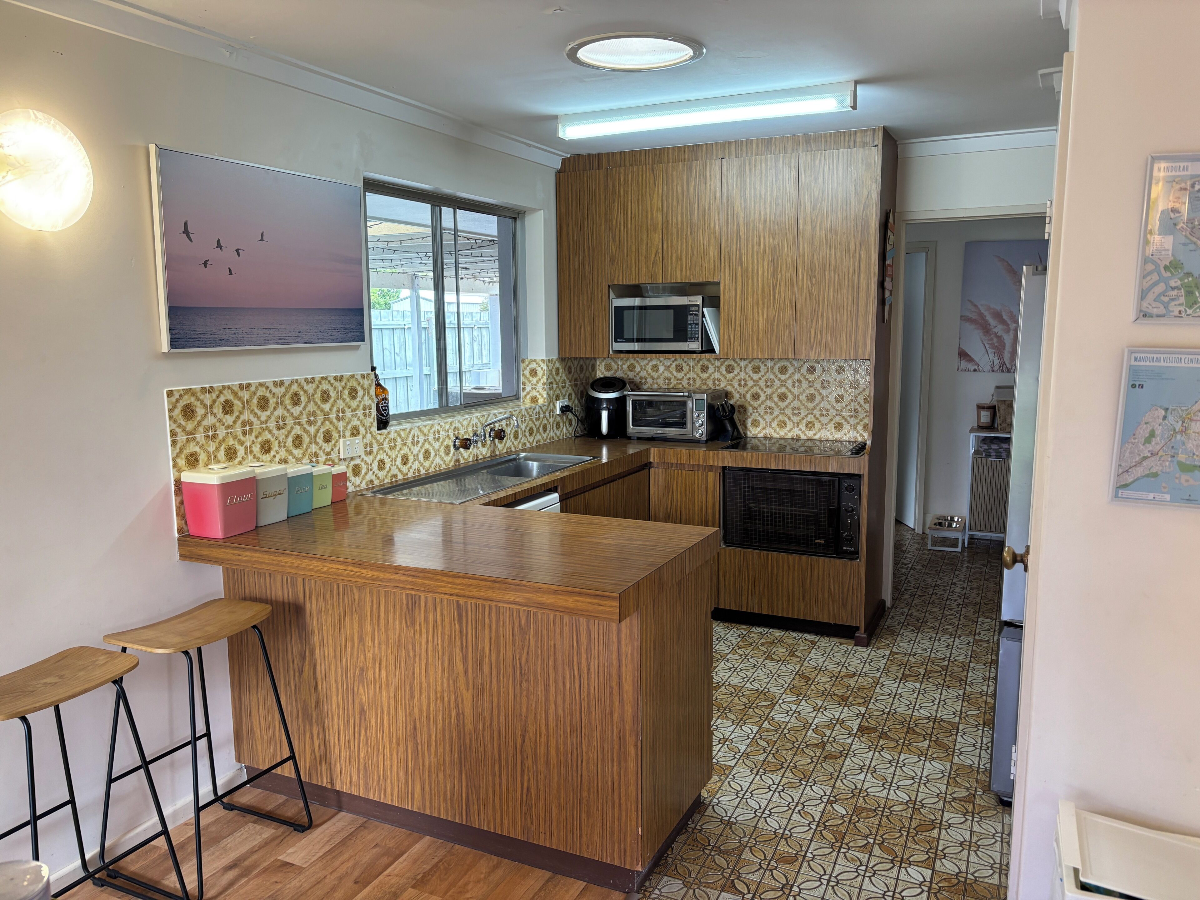 A kitchen with wooden cabinets, a microwave, a toaster, and a sink.