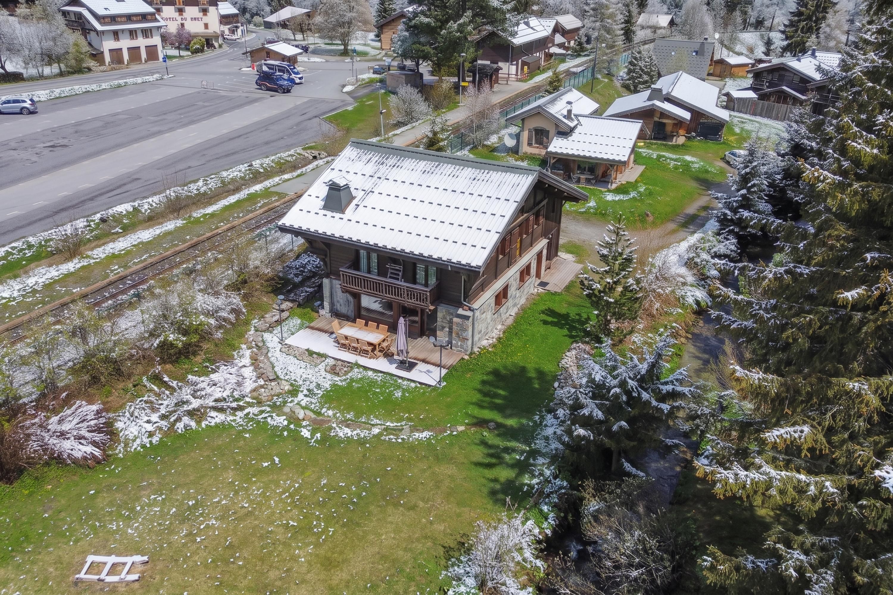 A modern lodge with a spacious patio, a covered outdoor seating area, and a view of a snow-covered landscape.
