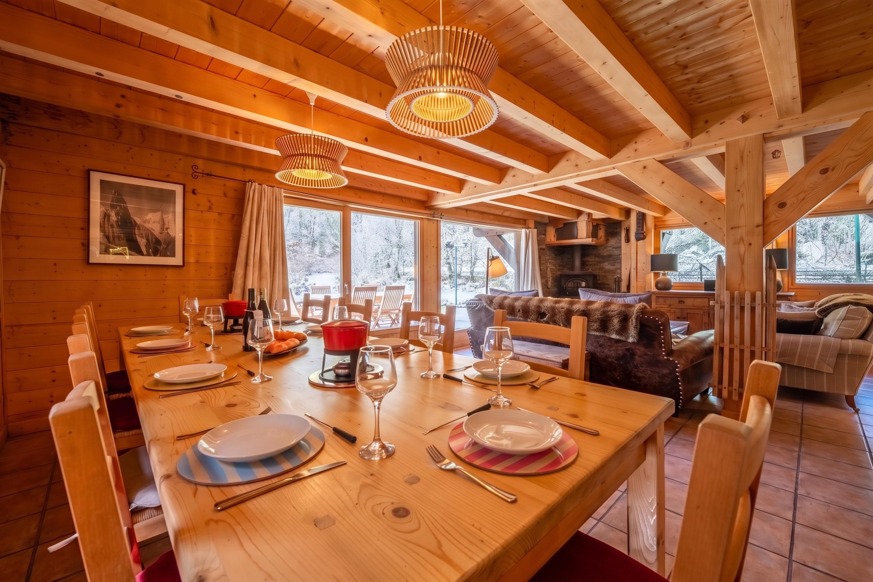 A wooden interior with a dining table set for a meal, a fireplace, and a cozy seating area.