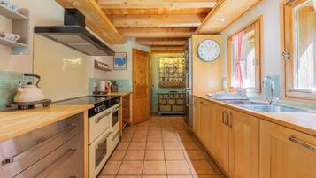 A kitchen with wooden cabinets, a stove, and a sink.