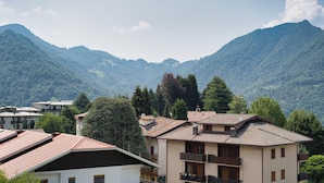 Un quartier résidentiel avec des maisons, dont certaines sont dotées de balcons, entouré de montagnes.