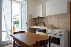 Kühlschrank, Herdplatte, Kochgeschirr/Geschirr/Besteck, Esstisch