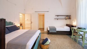 A room with a bed, a desk, a chair, a shelf with books, and a door leading to another room. - Dimora Lustrelle con parco privato (Cutrofiano)