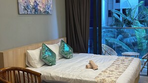 A hotel room with a bed, a dining table set with plates and a mug, a chair, a decorative pillow, and a painting on the wall. - Cozy studio apartment with balcony near KLCC, TRX, Gleneagles, Ampg Puteri Hosp (Kuala Lumpur)