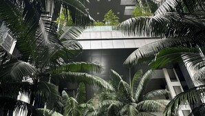 A modern building with multiple floors, surrounded by lush greenery and palm trees. - Cozy studio apartment with balcony near KLCC, TRX, Gleneagles, Ampg Puteri Hosp (Kuala Lumpur)