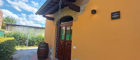 A building with a wooden door, a stone wall, and a metal chain.