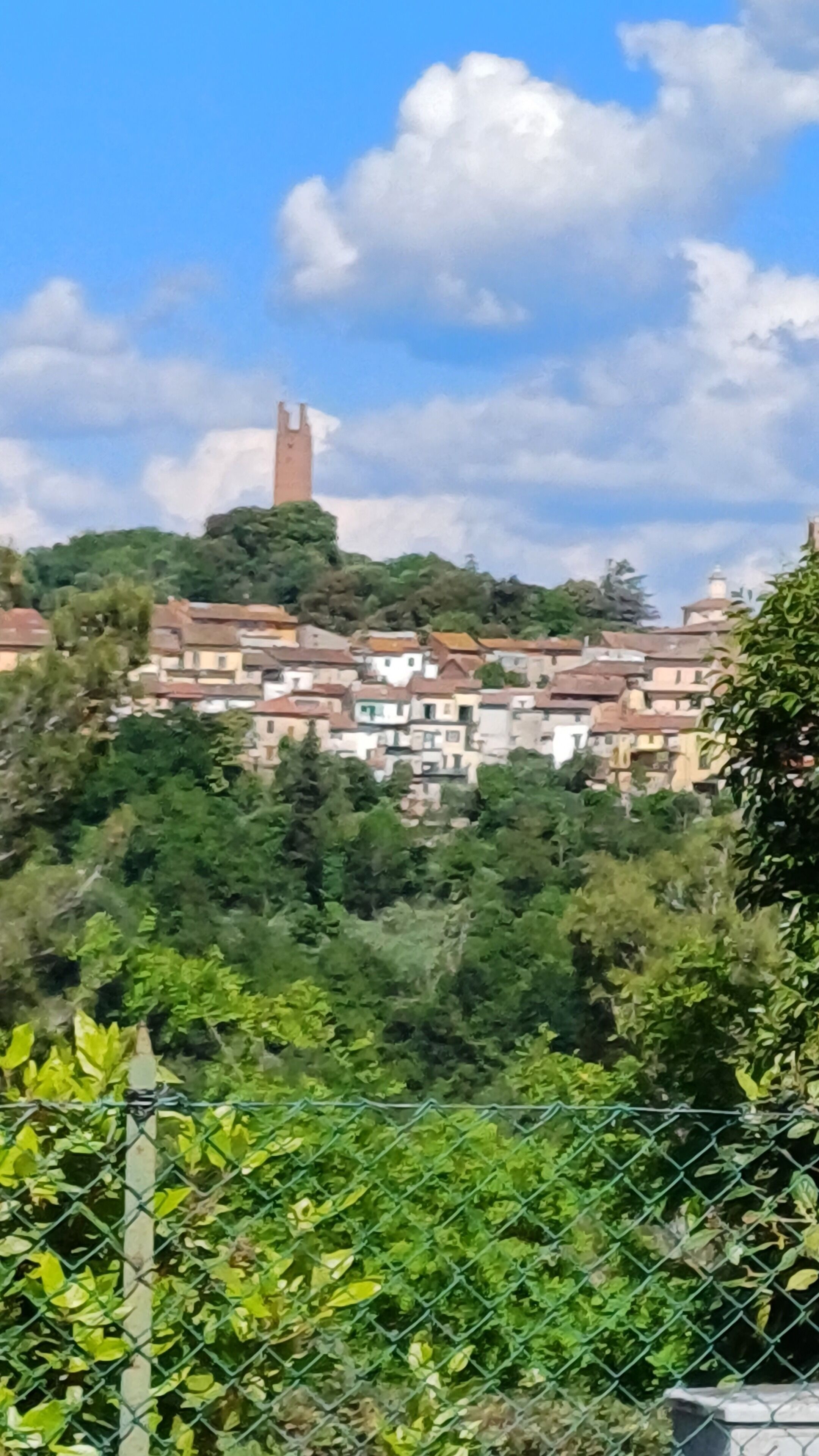 Un village perché sur une colline, avec des bâtiments traditionnels et une tour imposante.