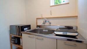 A compact kitchen with a stainless steel sink, a microwave, and a coffee maker on a shelf. - Fuyu no Sonata 2 (Nakafurano)