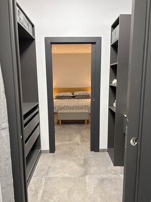 A bedroom with a bed, a bench, and a wardrobe. - Bilocale nel cuore di Genova (Genova)