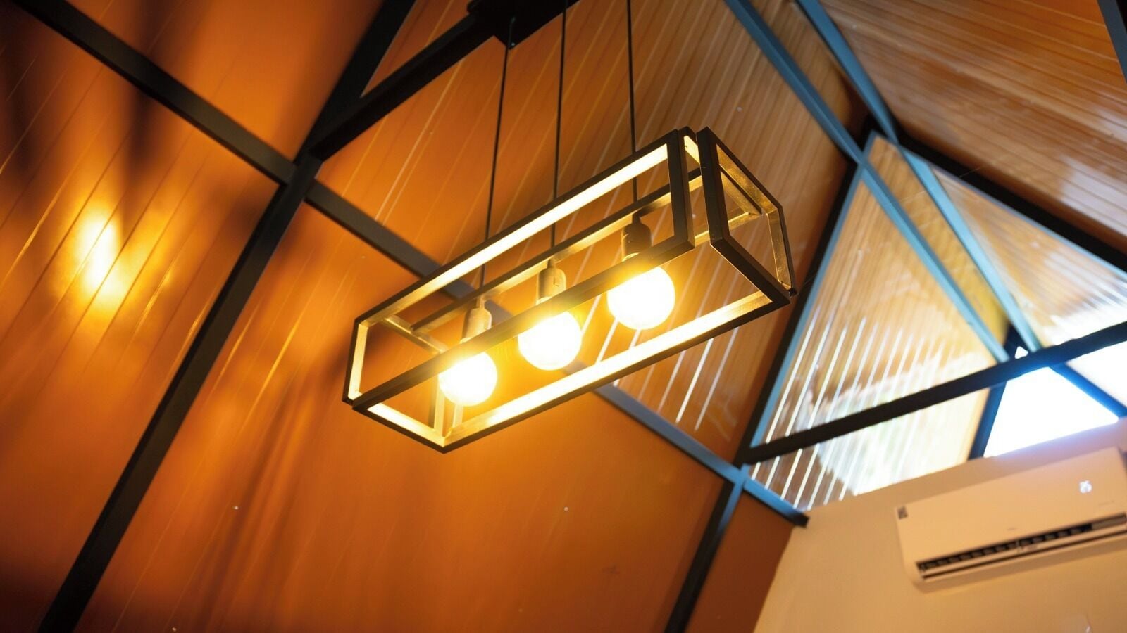 Decoração moderna com luminária geométrica e ar-condicionado.