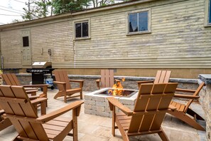 Area esterna con sedute in stile Adirondack e un braciere.