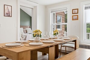 Comedor con mesa de madera dispuesta para seis personas, rodeada de sillas.