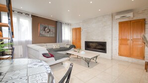 Ein Wohnzimmer mit Sofa, Couchtisch, Kamin und Holzsäcken.