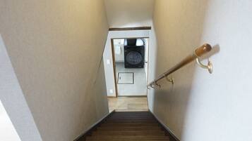 A narrow stairway leading to a laundry room with a washing machine and dryer.