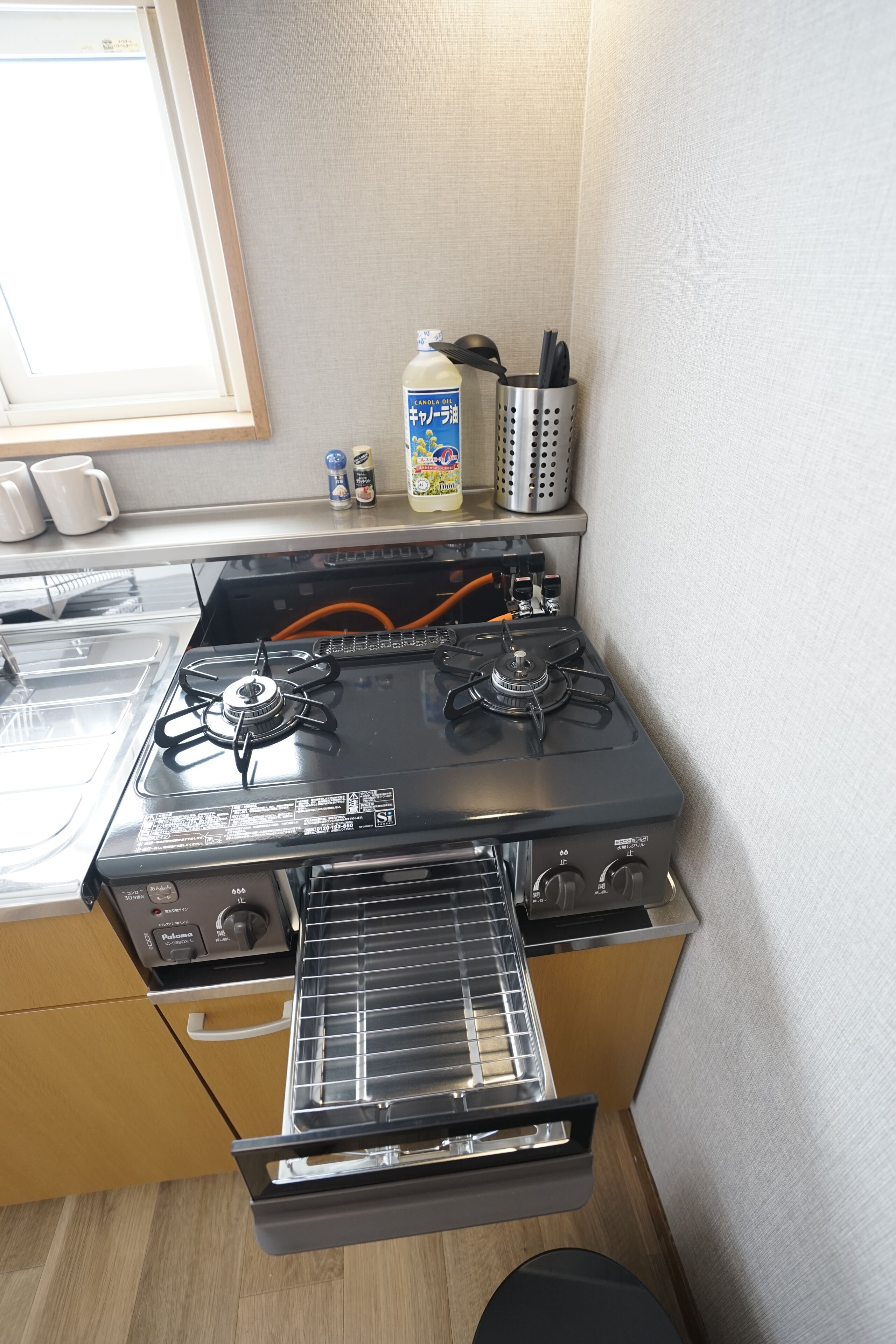 A compact kitchen with a gas stove, oven, and a small countertop with kitchen utensils.