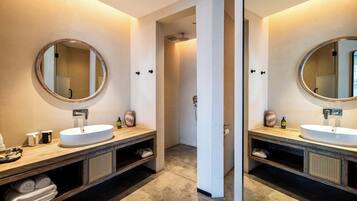 Ein modernes Badezimmer mit zwei Waschbecken, einem Spiegel und einer Dusche.