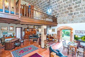 A spacious living area with a piano, seating, and a view of the outdoors. - Fort Galantè, Alghero, Italy (Alghero)
