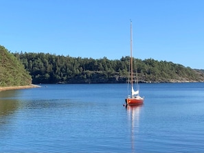 A sailboat on calm water with a forested shoreline in the background. - 5 Star Holiday Home in Uddevalla (Uddevalla)