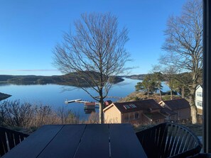A lakeside view with a dock, houses, and a clear sky. - 5 Star Holiday Home in Uddevalla (Uddevalla)