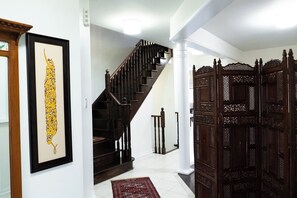 A staircase with wooden railings, a framed artwork on the wall, and a patterned rug on the floor. - Lake Getaway in Barrie (Barrie)