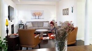 A living room with a sofa, chairs, a coffee table, and a vase with flowers. - Lake Getaway in Barrie (Barrie)