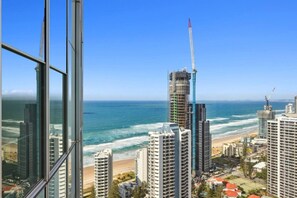 A coastal cityscape with high-rise buildings, a beach, and a clear blue sky. - level 32 Skyline Serenity in Surfers Paradise Q1 (Surfers Paradise)